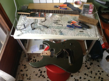 Guitarra despedazada y con piezas rotas, que son las que se sustituyen.